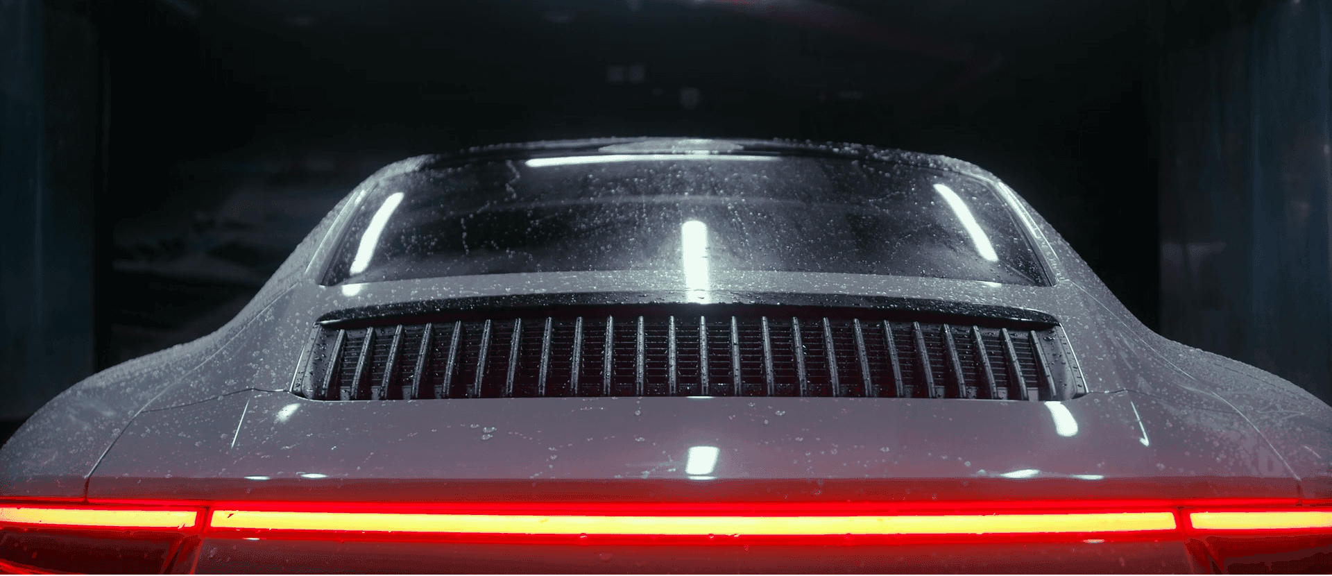 Water rinsing foam off a sports car during an Auto Gleam Details wash